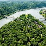 Aerial view of the lush green canopy surrounding the Three Rivers in Pittsburgh