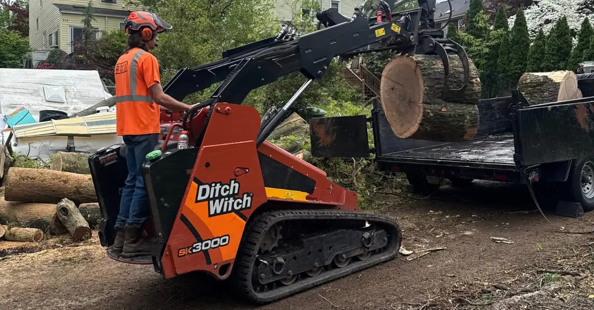 Professional crew loading tree debris into specialized hauling equipment in Pittsburgh